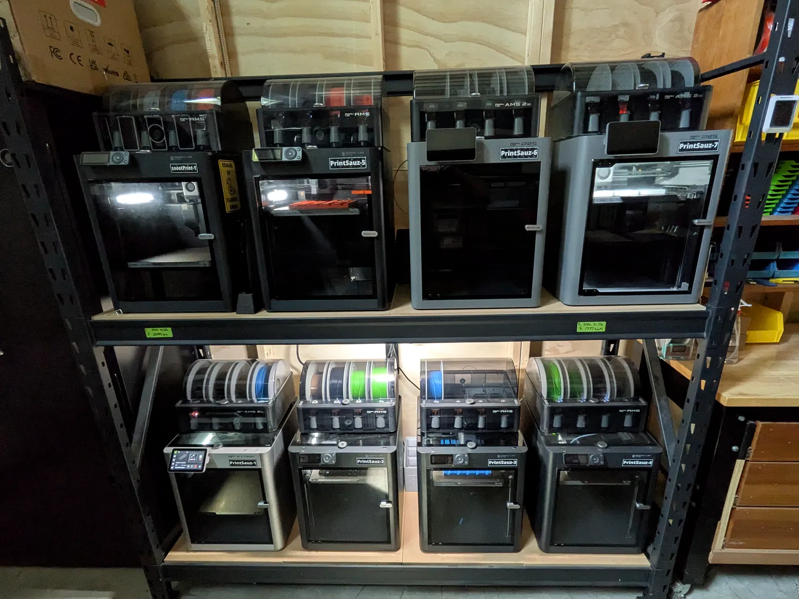 Zengineer's Workshop's wall of named Bambu Lab printers with AMS units, running production overnight.